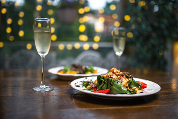 glasses of champagne and salads on bokeh background
