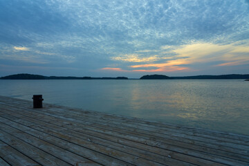 A wooden mole with mooring bollards on a sunset. Copy space.