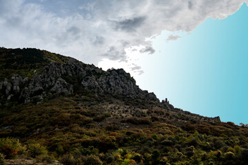 panoramic view of yellow autumn mountains against a background of blue haze and storm clouds