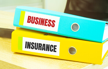 Two office folders with text BUSINESS INSURANCE