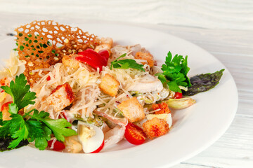 summer vegetable salad on a white dish on a wooden background