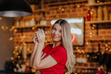 Young woman posing with small grey rat on a kitchen. Christmas background.