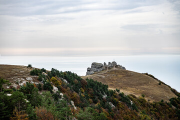 panoramic view of yellow autumn mountains against a background of blue haze and storm clouds filmed from a drone