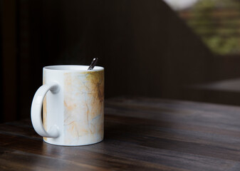 White cup on table and dark background