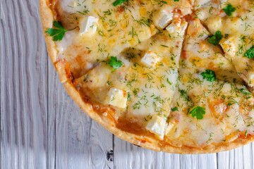 pizza with cheese vegetables and meat on a wooden background
