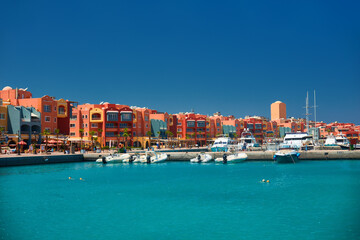 Fototapeta na wymiar panoramic seascape on colorful Marina promenade street from Red Sea with moored motor yachts. Marina, Hurghada, Egypt
