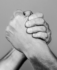 Hand rivalry vs challenge strength comparison. Two men arm wrestling. Arms wrestling. Closep up. Friendly handshake, friends greeting, teamwork, friendship. Black and white