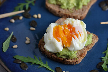 Sandwich with avocado and poached egg. Healthy eating concept