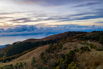 panoramic view of yellow autumn mountains against a background of blue haze and storm clouds filmed from a drone