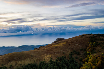 panoramic view of yellow autumn mountains against a background of blue haze and storm clouds filmed from a drone