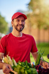 Young happy caucasian male courier delivering grocery