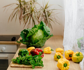 beautiful fresh vegetables on the table in the kitchen. Harvesting. Bell pepper, huge green cabbage and green mint stalks.