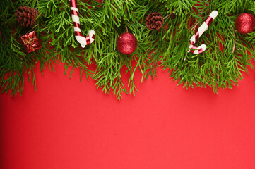 Christmas border made of fir branches, festive red decoration.