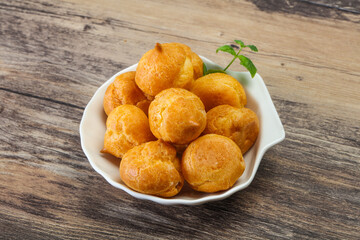 Sweet tasty profiteroles heap in the bowl