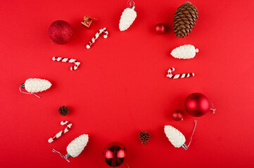 Creative layout made of Christmas decorations on red table.