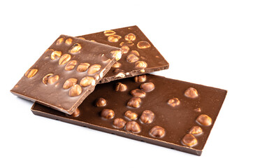 Appetizing chocolate with whole hazelnuts on a white plate