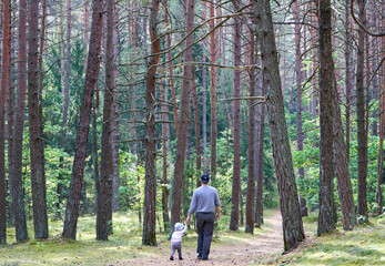 Obraz premium Parent and child walking in the forest