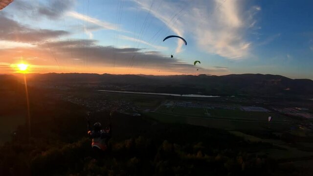 Peaceful evening paragliding flight with friends at sunset