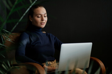Makes an order in the online store at home. portrait of a beautiful Caucasian woman appearance, stylish comfortable clothes for work. holding a laptop computer report on work statistics.