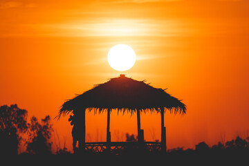 Silhouette hut on sunset background