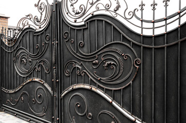 Beautiful metal gate, decorated with wrought iron elements in a retro style. Private property protection