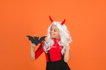 happy halloween party girl wearing cosplay costume and having fun while celebrating autumn traditional holiday holding bat, halloween accessory