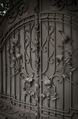 Beautiful finishing of metal gates with forged elements in black and white colors. Beauty and protection