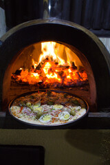 Pizza portuguesa com ovo assada no forno a lenha