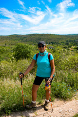 Mujer de mediana edad haciendo trekkings en sierras de córdoba camino a una cascada con hermosa...