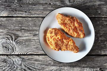 breaded chicken breasts on a grey plate, top view