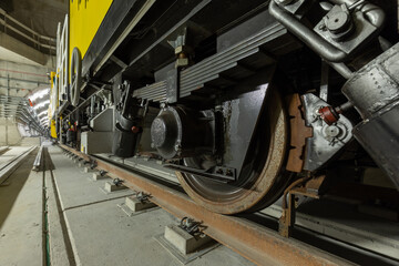 Closeup of the railway maintenance vehicle. Train wheels on rails.