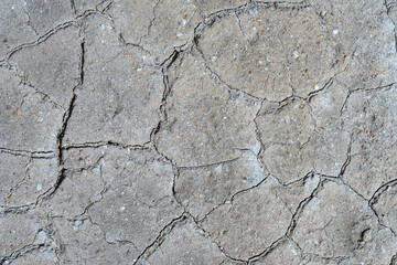 Gray dry cracked surface of volcanic ground turned into desert. Natural pattern texture or background taken in environment in crater of active volcano. Concept: drought soil erosion, global warming.