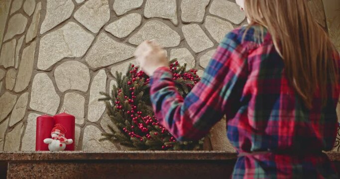 Woman decorating fireplace for Christmas with a wreath and candles. Close up. Dolly shot. 4k graded from RAW. UHD, Ultra HD resolution. 