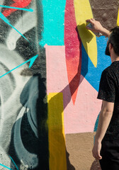 personne en train de faire des graffitis sur un mur, street art