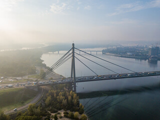 Aerial drone view. North bridge in Kiev in the rays of a sunny morning. Autumn haze in the air, cars are driving across the bridge.