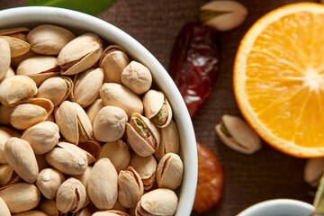 Various raw nuts: hazelnuts, pistachios, chestnuts, dates and oranges.