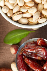 Various raw nuts: hazelnuts, pistachios, chestnuts, dates and oranges.