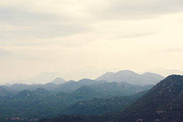 Mountain range with visible silhouettes through the morning colorful fog