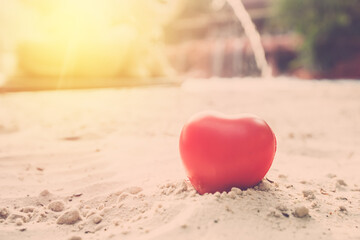 valentine day background. love red heart on sand beach close up, vintage filter