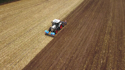 Traktor mit Grubber bearbeitet Acker, Landwirtschaft Luftbild