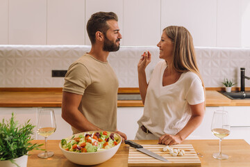 young couple laughing and working together with copy space in a nice kitchen 