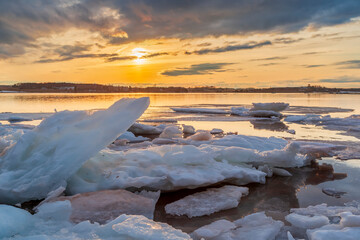 Winter scene with frozen ice sheets floating on a lake during a cool late sunset in Charlottetown, Prince Edward Island, Canada.