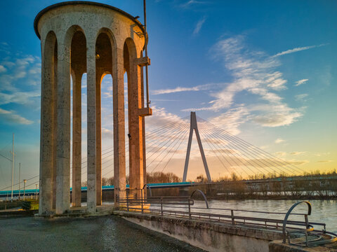 Gauge tower of Neuwied, Germany at the river Rhine with a bridge in background and blue sky in the evening sun - copy space