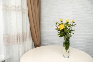 yellow roses in the vase standing over the white wall