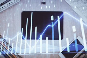 Double exposure of forex graph hologram over desktop with phone. Top view. Mobile trade platform concept.