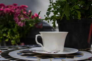 Obraz na płótnie Canvas White coffee cup and a pot of pink chrysanthemums