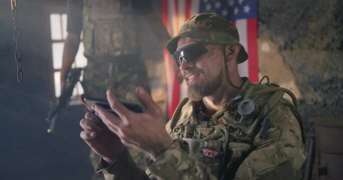 American soldier showing smartphone to friend