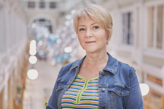 Mature European Woman With Short White Hair Inside A Shopping Mall, Close-up Portrait.