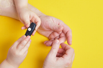 Fototapeta premium grandmother is doing glucose level finger blood test to child