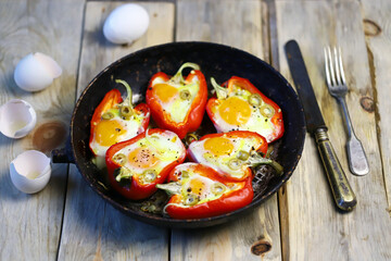 Selective focus. Red peppers with eggs baked in a frying pan. The keto diet. Keto lunch idea.